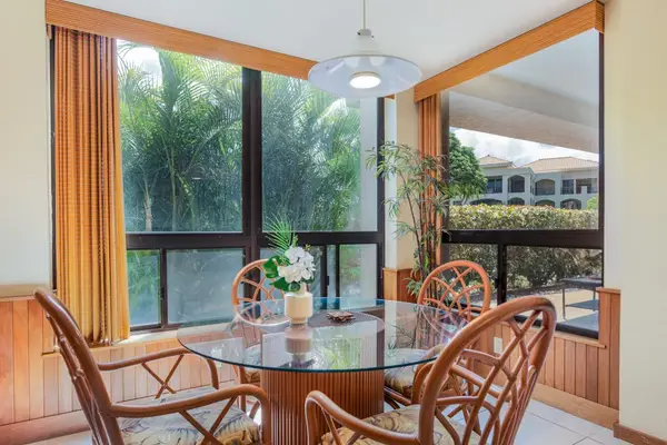 Glass-Top Dining Table Surrounded by Panoramic Garden Views