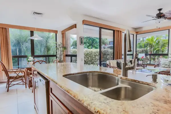 Open Kitchen Island Sink Overlooking Bright Living & Dining Areas