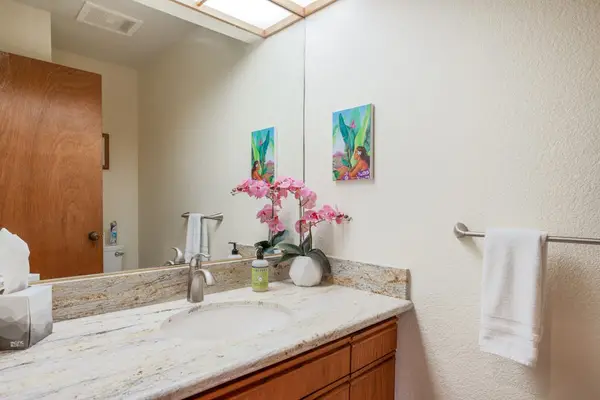 Spacious Bathroom Vanity with Granite Countertop & Warm Lighting
