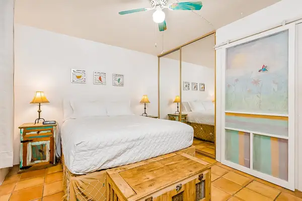 First bedroom features a bed, bedside tables, lamps, and wardrobe