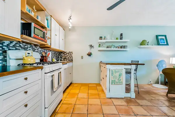 Spacious kitchen displays generous cabinetry, island counter, appliances, and seating