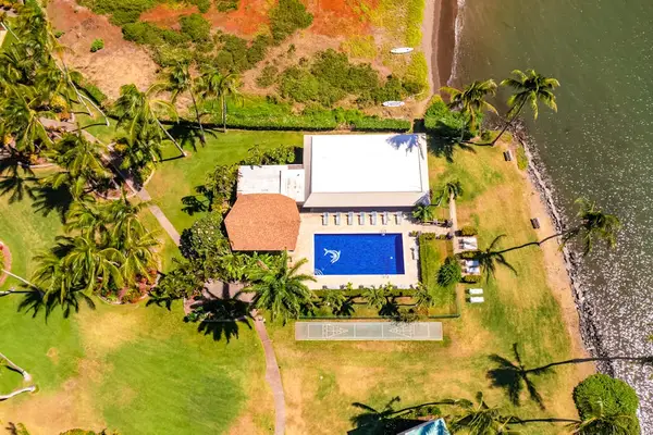 Top-down property view highlights pool, buildings, palms, lawn, and pathways