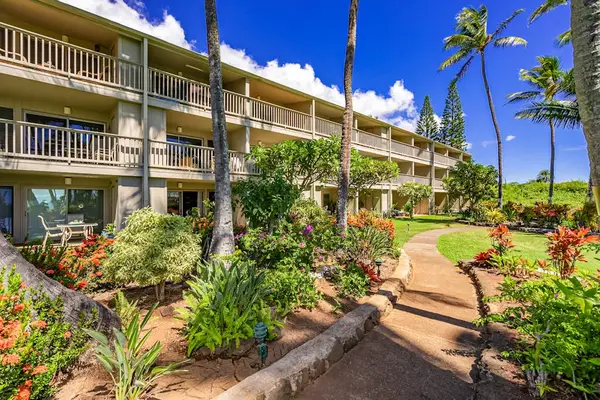 Tropical resort walkway leads through landscaped gardens beside guest accommodations