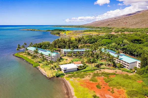 Resort view captures turquoise sea, shoreline, buildings, and mountain landscape
