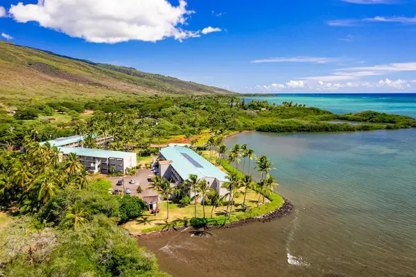 Aerial view reveals resort buildings, coastline, ocean, and mountain scenery