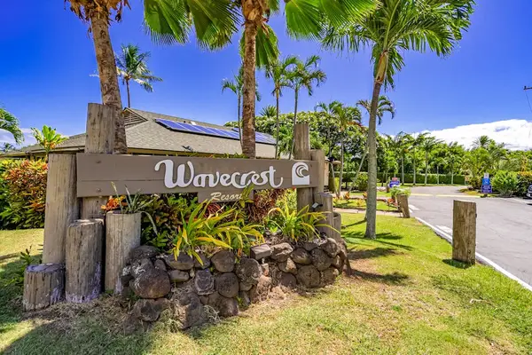 Wavecrest entrance sign welcomes guests beside palms and landscaped grounds