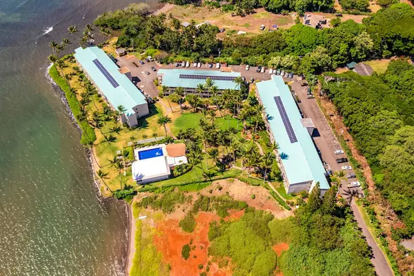 Aerial property layout shows buildings, pool, shoreline, gardens, and water