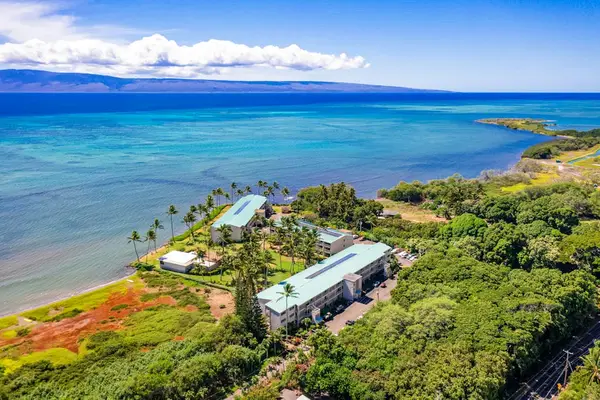 Aerial coastline panorama shows turquoise water, resort shoreline, and mountains