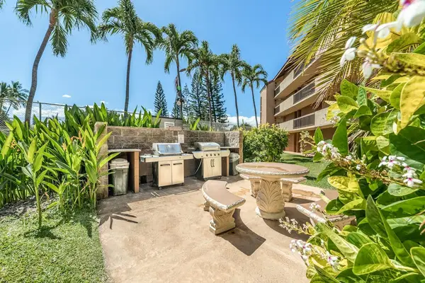 Outdoor BBQ area with seating surrounded by lush greenery