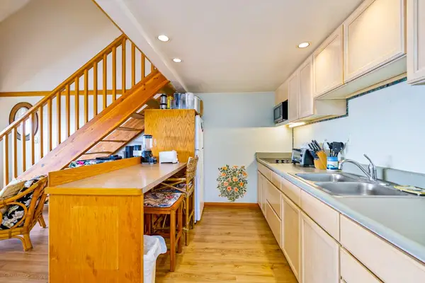 Well-equipped kitchen features wooden cabinets counters and useful appliances throughout