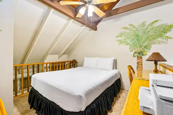 Wood-beamed loft bedroom offers queen bed and cozy island retreat
