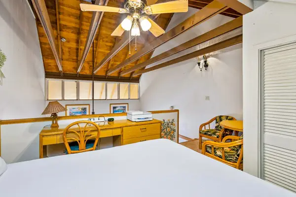 Loft sitting area offers a table chairs and wood ceiling