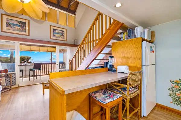Coastal living area opens toward the staircase with seating nearby