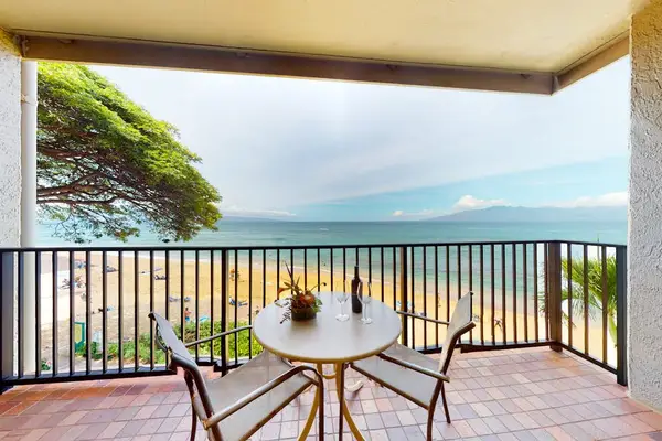 Private lanai with a dining table, overlooking the beach and ocean.