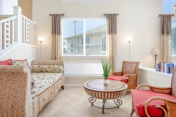 Sunlit Living Room Lounge with Accent Seating & Staircase Access