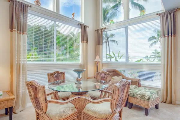 Sunlit Dining Area with Glass-Top Table & Vaulted Windows