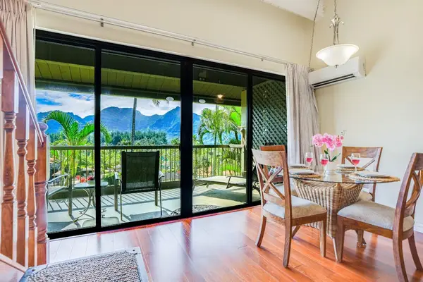 Enjoy morning coffee beside bright windows overlooking lush tropical scenery