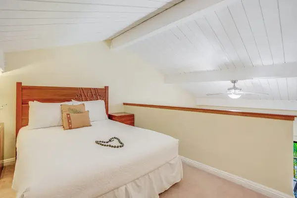 Rest peacefully in this cozy bedroom beneath charming vaulted ceilings