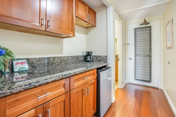 Kitchen features granite countertops, wooden cabinetry, convenient, essential appliances