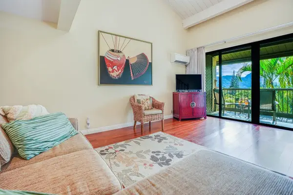 Bright living room includes colorful seating, artwork, and sliding doors