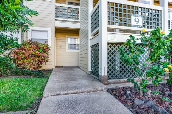 Welcoming Condo Entrance Surrounded By Greenery