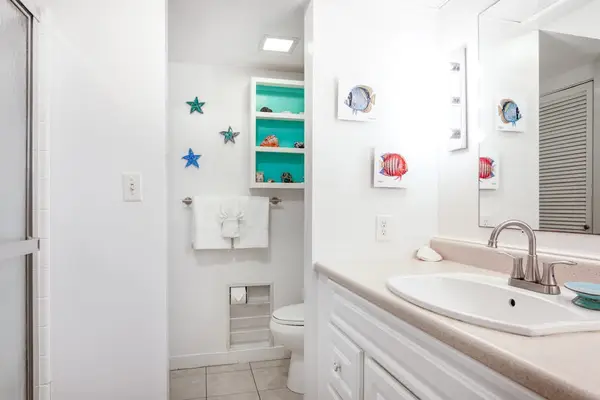 Clean Full Bathroom with Large Vanity, Mirror & Storage Shelving