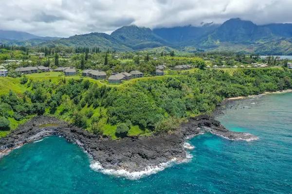 Bird’s-eye coastline view highlights turquoise bays, tropical vegetation, and cliffs