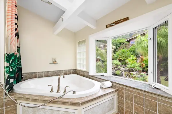 Sunlit bathroom overlooking leafy garden views