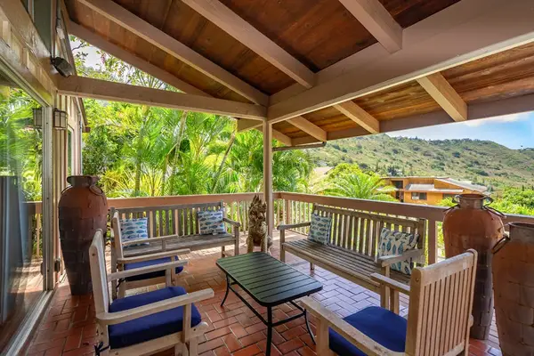 Lanai bordered by leafy greenery for outdoor seating
