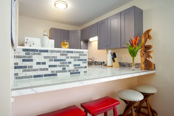 Kitchen counter with four barstools for extra seating.