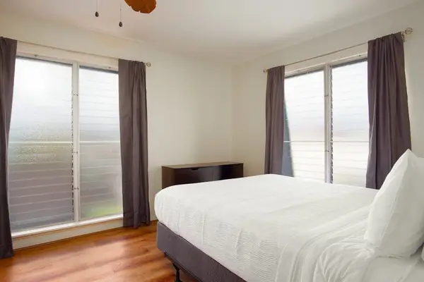 Master bedroom with queen bed, ac and floor to window windows.