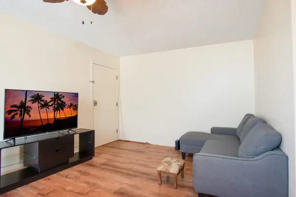 Living room with ceiling fan and flat screen tv.