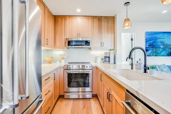 Modern Kitchen Featuring Quartz Countertops, Wooden Cabinets & Stainless Steel Range