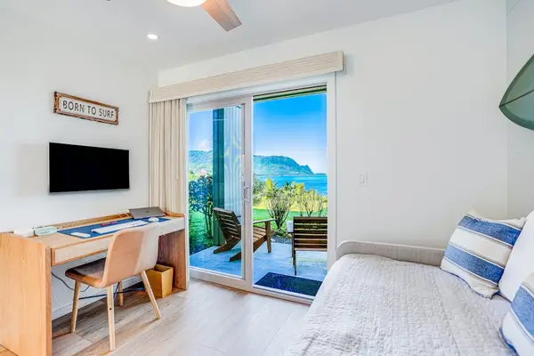Cozy Bedroom Workspace with Dedicated Desk, Wall-Mounted TV & Sliding Patio Door