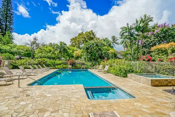 Resort-Style Outdoor Swimming Pool Area surrounded by Tropical Gardens and Sun Loungers