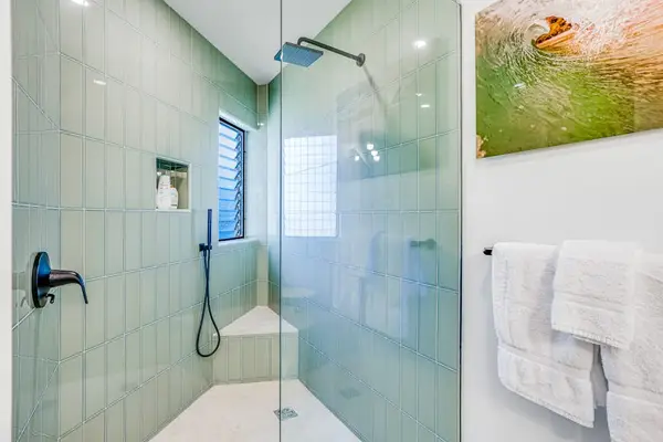 Refreshing Walk-In Shower highlighted by Sage Green Vertical Tile & Bench Seating