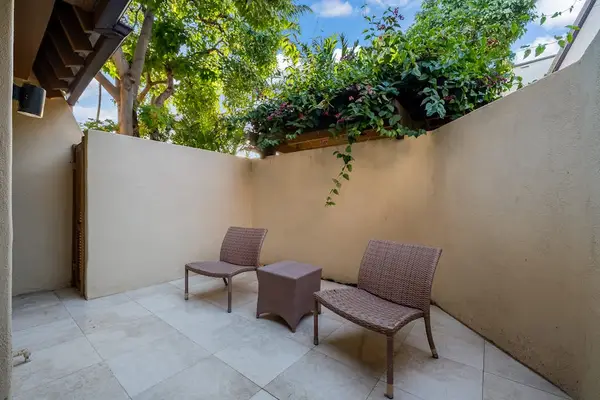Patio seating invites relaxed mornings surrounded by vibrant tropical gardens