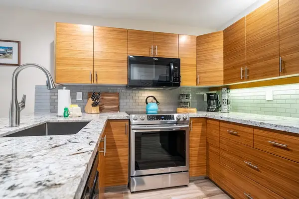 Bright kitchen combines practical appliances spacious counters and easy island meal preparation
