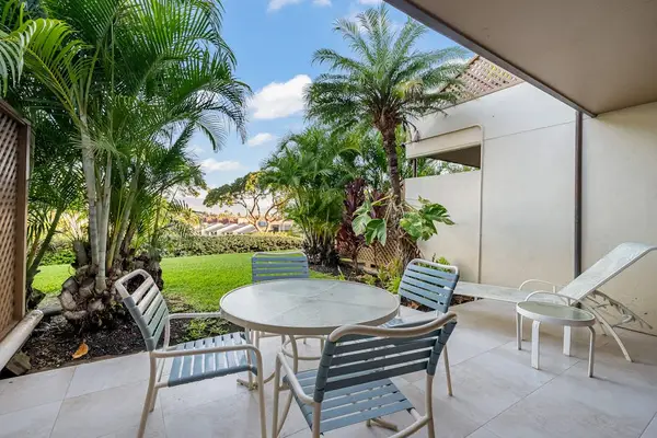 Patio table overlooks tropical gardens beside comfortable outdoor chairs