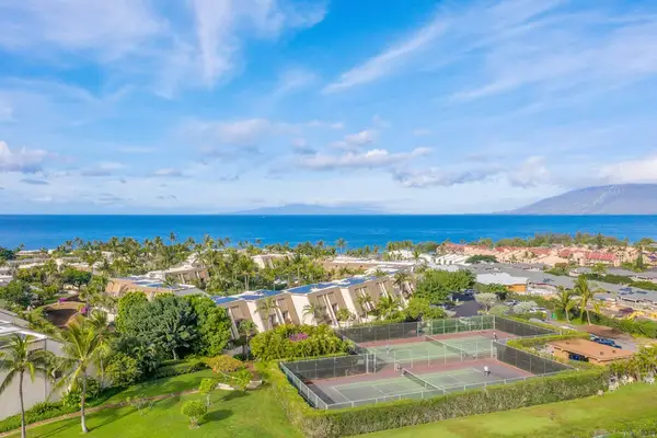 Aerial ocean view reveals vivid blue water surrounding lush island scenery