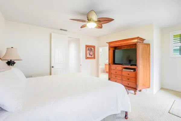 Guest bedroom with flat screen tv and a queen bed.