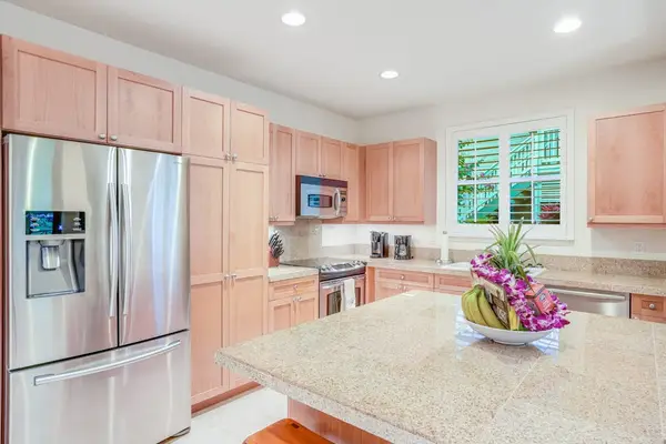 Newly remodeled kitchen with stainless steel appliances and a large island for extra counter space.