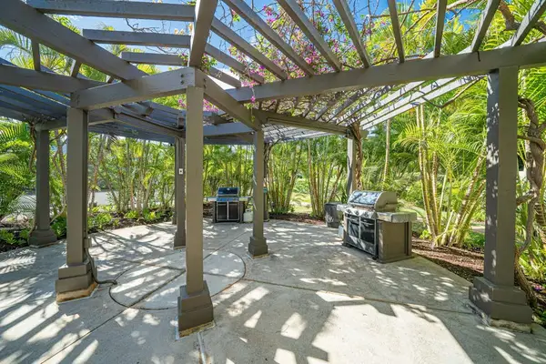 Shaded pergola creates outdoor gathering area surrounded by nearby greenery