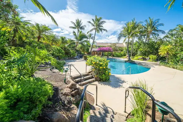 Resort pool and tropical gardens welcome guests with island surroundings