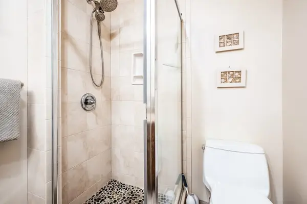 Full bathroom includes glass shower enclosure toilet and wall controls