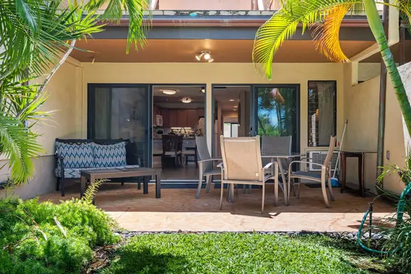 Tropical patio welcomes guests with outdoor seating and landscaped surroundings