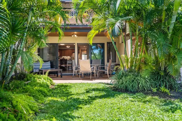 Tropical garden path leads toward welcoming condo outdoor seating area