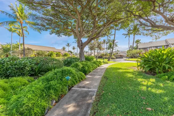 Garden walkway leads through manicured grounds toward Maui Kamaole residence