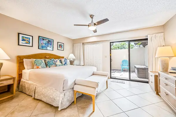 This bedroom pairs comfortable bed ceiling fan with patio access