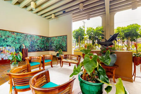 Covered open-air lobby seating area surrounded by beautiful tropical plants
